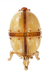 Souvenir egg made of amber plates on a stand